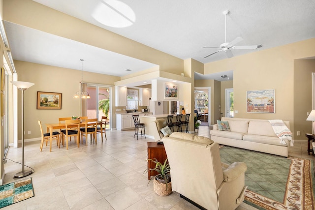 living room featuring light tile patterned floors, ceiling fan with notable chandelier, lofted ceiling, and a healthy amount of sunlight