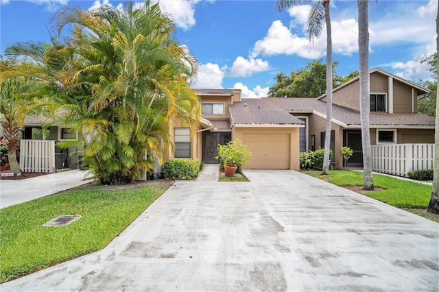 townhome / multi-family property featuring a garage and a front lawn