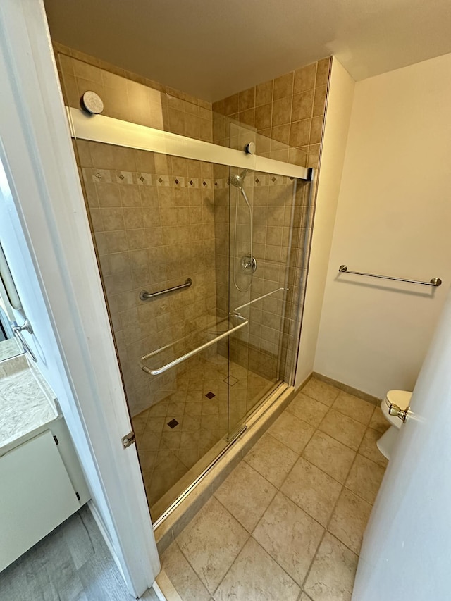 bathroom with tile patterned flooring, toilet, and walk in shower