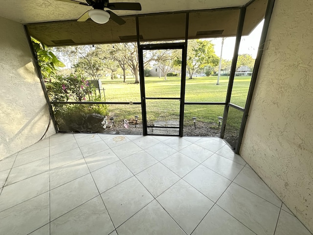 unfurnished sunroom featuring ceiling fan