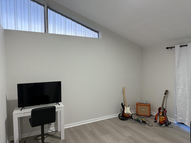 misc room with light hardwood / wood-style flooring and lofted ceiling