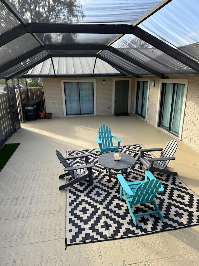 view of patio featuring glass enclosure