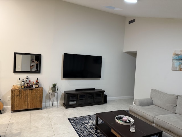 living room with bar, lofted ceiling, and light tile patterned floors