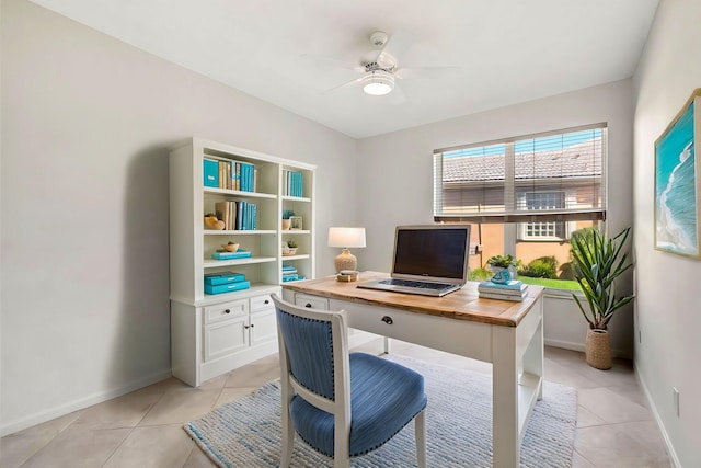 home office featuring a ceiling fan, baseboards, and light tile patterned floors