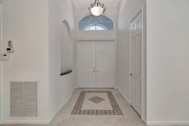 entryway with light tile patterned flooring, visible vents, and baseboards