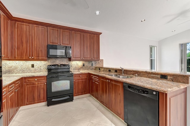 kitchen featuring light tile patterned floors, light stone counters, a peninsula, a sink, and black appliances