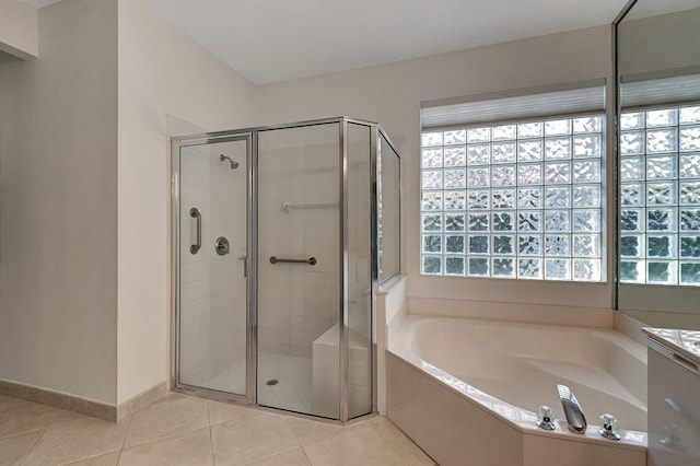 bathroom with tile patterned flooring, a shower stall, baseboards, and a bath