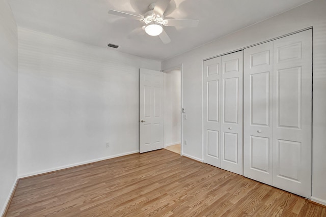 unfurnished bedroom featuring light wood-style floors, a ceiling fan, baseboards, and a closet