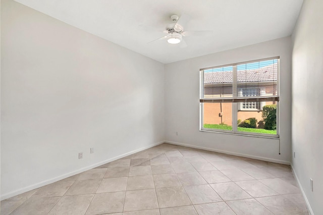 unfurnished room featuring ceiling fan, baseboards, and light tile patterned flooring