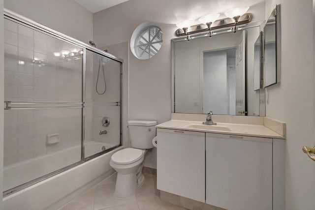 full bath featuring enclosed tub / shower combo, vanity, toilet, and tile patterned floors