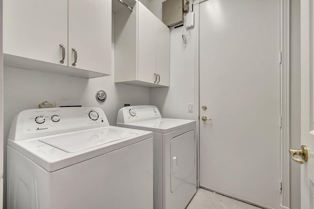 washroom with light tile patterned floors, cabinet space, and separate washer and dryer