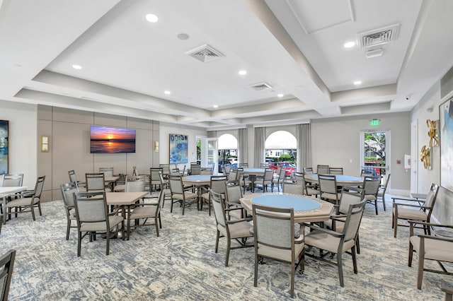 dining space with a raised ceiling and visible vents