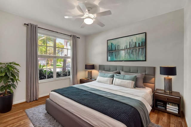 bedroom featuring ceiling fan, baseboards, and wood finished floors