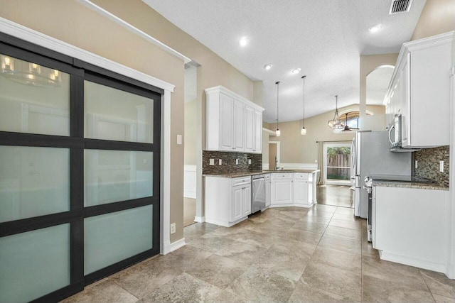 kitchen with stainless steel appliances, white cabinets, lofted ceiling, tasteful backsplash, and pendant lighting