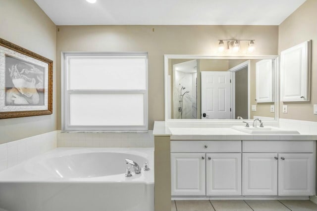 bathroom with a bathing tub, tile patterned flooring, and vanity