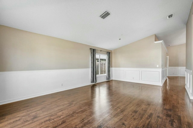 empty room featuring lofted ceiling and dark wood-type flooring