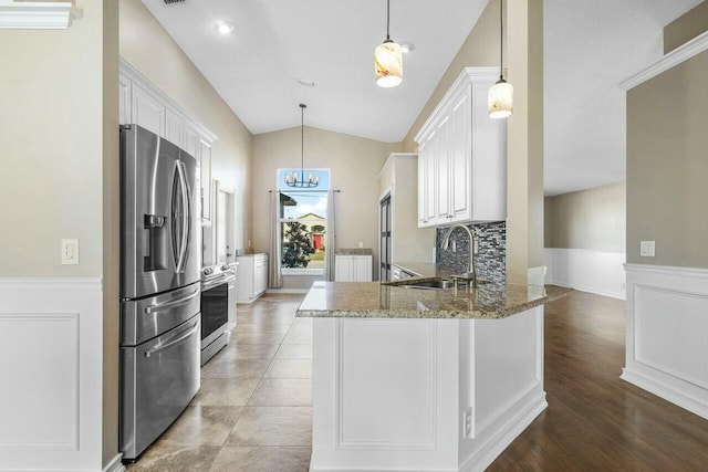 kitchen featuring appliances with stainless steel finishes, white cabinetry, kitchen peninsula, and sink