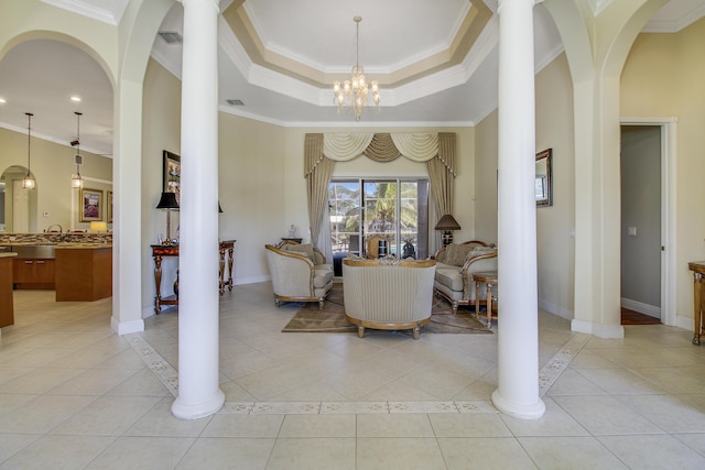 tiled living room with a notable chandelier, ornamental molding, and a tray ceiling