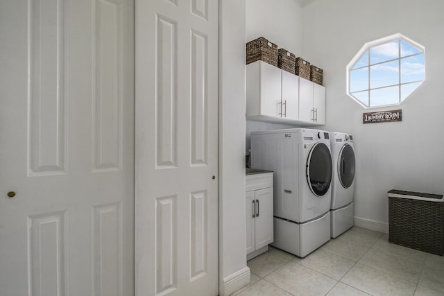 washroom with washing machine and clothes dryer, light tile patterned floors, and cabinets