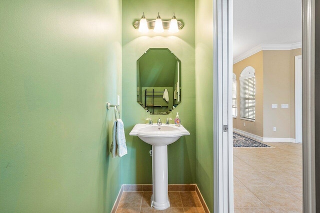 bathroom with tile patterned floors, crown molding, and sink