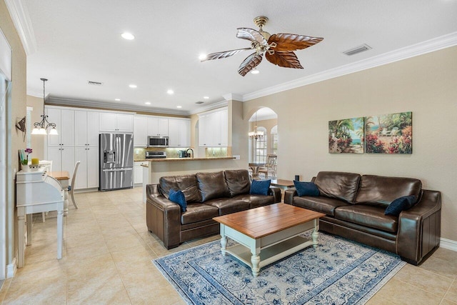 living room with light tile patterned floors, ceiling fan with notable chandelier, and ornamental molding