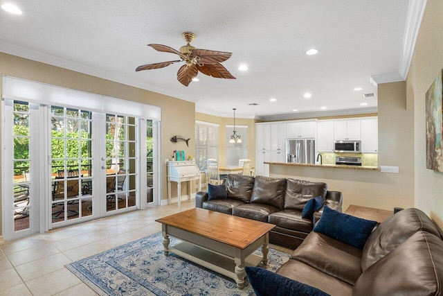 living room featuring french doors, ceiling fan with notable chandelier, sink, ornamental molding, and light tile patterned flooring