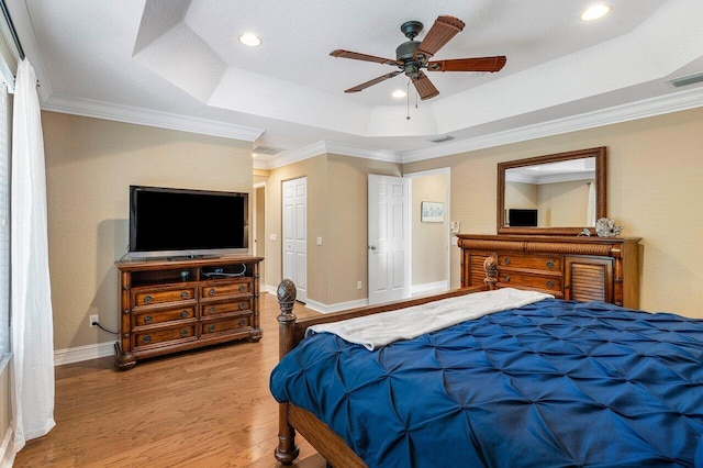 bedroom featuring a raised ceiling, ceiling fan, hardwood / wood-style floors, and crown molding