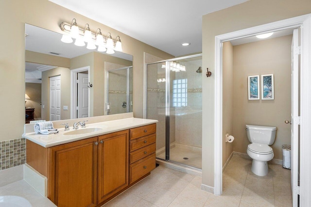 bathroom featuring tile patterned floors, vanity, toilet, and a shower with door