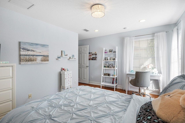 bedroom featuring wood-type flooring and a textured ceiling