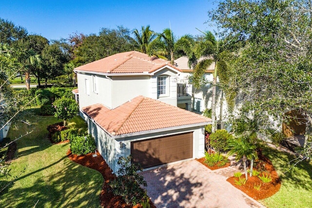 mediterranean / spanish-style home featuring a front yard and a garage