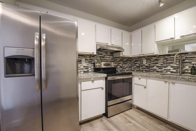 kitchen with sink, light wood-type flooring, appliances with stainless steel finishes, tasteful backsplash, and white cabinetry