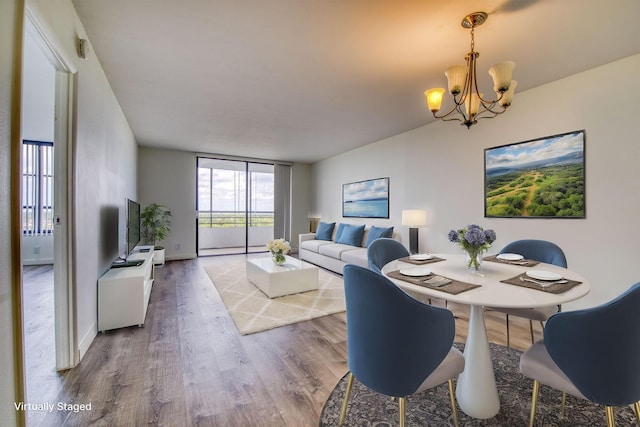 dining area featuring a chandelier, wood finished floors, and baseboards