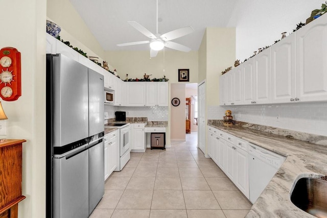 kitchen featuring white appliances, ceiling fan, light tile patterned flooring, light stone counters, and white cabinetry