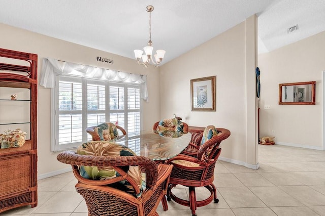 dining space with light tile patterned flooring, lofted ceiling, and a chandelier