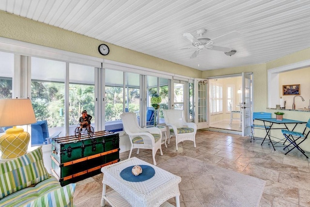 sunroom / solarium featuring ceiling fan, sink, and french doors