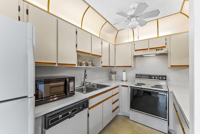 kitchen with white appliances, light tile patterned floors, light countertops, under cabinet range hood, and a sink