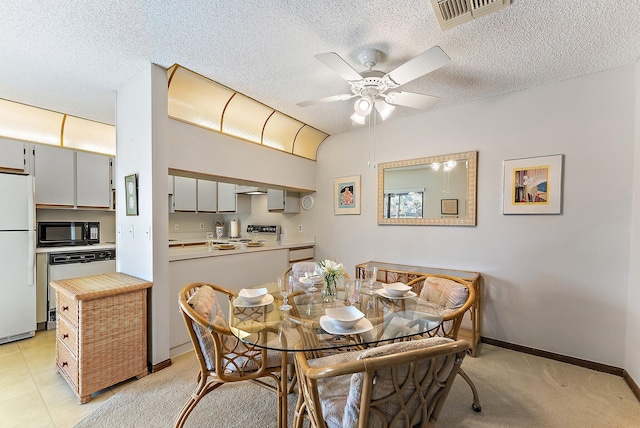 dining room with a textured ceiling, baseboards, visible vents, and a ceiling fan