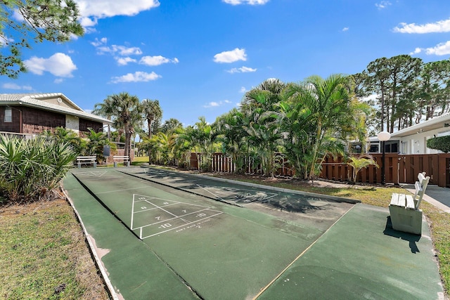 view of home's community with shuffleboard and fence