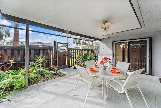 unfurnished sunroom featuring ceiling fan