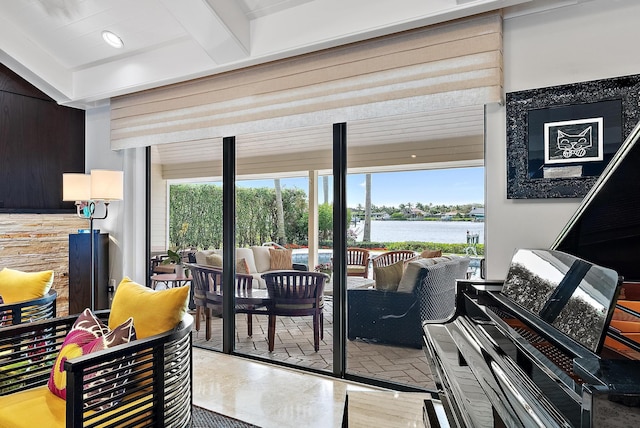 entryway featuring a water view, plenty of natural light, and beamed ceiling