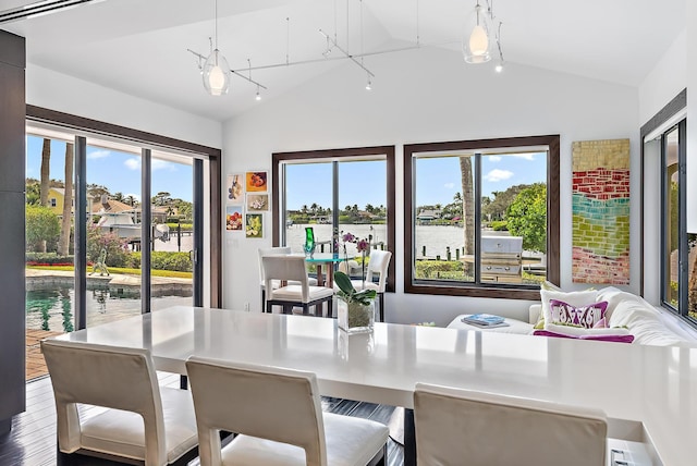 dining room with lofted ceiling and a water view