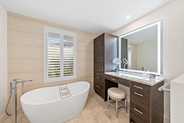 bathroom featuring tile walls, a bathtub, and vanity