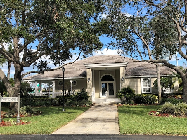 view of front of home with a tile roof and a front lawn