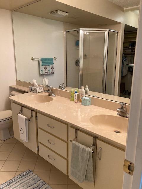 bathroom featuring tile patterned floors, walk in shower, toilet, and vanity