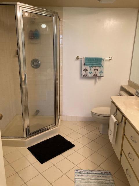 bathroom with vanity, toilet, tile patterned floors, and an enclosed shower