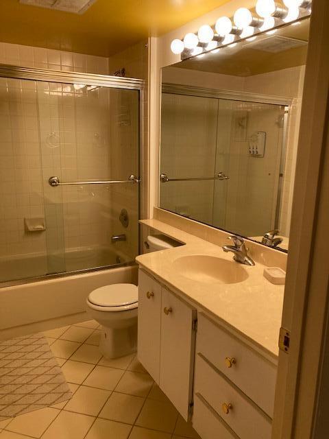 full bathroom featuring shower / bath combination with glass door, vanity, toilet, and tile patterned flooring