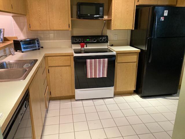 kitchen with sink, black appliances, tasteful backsplash, and light tile patterned flooring