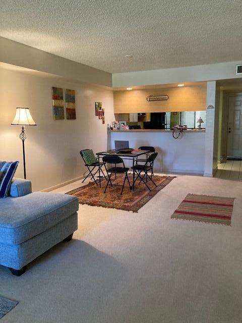 carpeted living room featuring a textured ceiling