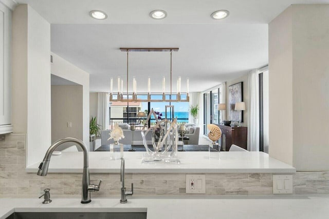 kitchen with decorative light fixtures, sink, and decorative backsplash