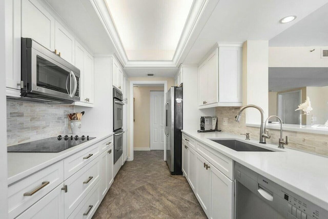 kitchen with white cabinets, backsplash, appliances with stainless steel finishes, and sink